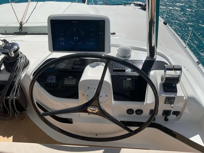 Jdmontt Yacht Photos Pics Steering wheel and controls of 2024 Lagoon 55 yacht, featuring modern navigation display.