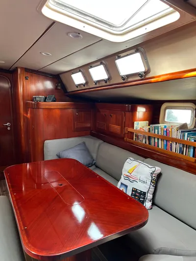 Southern Sky Yacht Photos Pics Interior of 1991 Beneteau Oceanis 510 sailboat with wooden table and cozy seating.