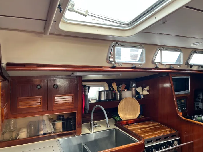 Southern Sky Yacht Photos Pics Interior of 1991 Beneteau Oceanis 510 yacht kitchen with wooden cabinetry and stainless steel sink.