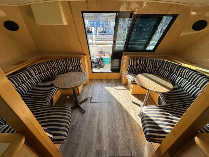  Yacht Photos Pics Interior of 2000 Bluewater Yachts 5200 Millenium with striped seating and wooden tables.