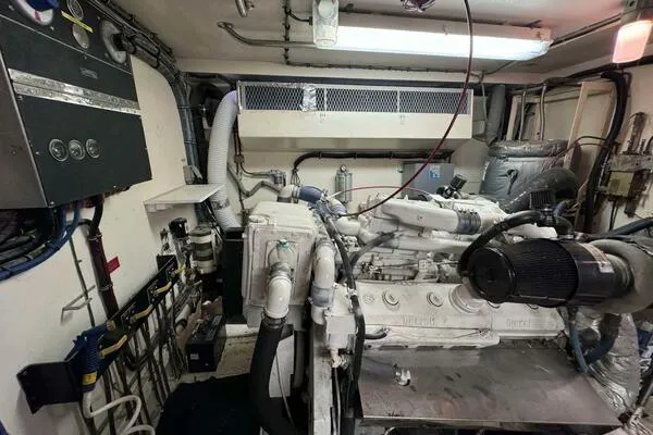 Still Pure Joy Yacht Photos Pics Engine room of a 1987 Hatteras 63 yacht, featuring complex machinery and piping.