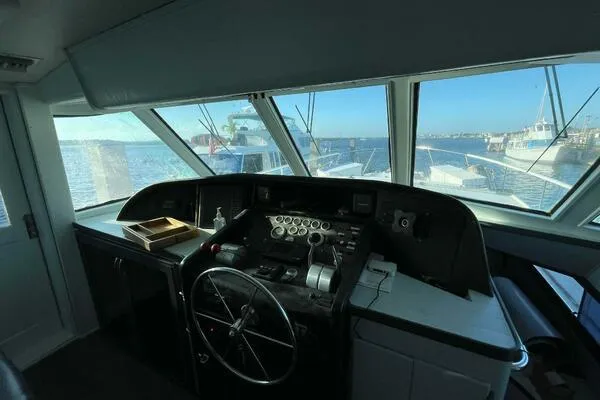 Still Pure Joy Yacht Photos Pics Interior helm of 1987 Hatteras 63 yacht with steering wheel and control panel.