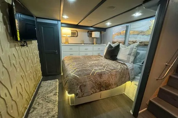 Still Pure Joy Yacht Photos Pics Luxurious bedroom interior of a 1987 Hatteras 63 yacht with modern decor and ambient lighting.