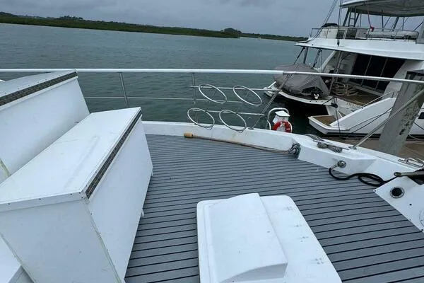 Still Pure Joy Yacht Photos Pics 1987 Hatteras 63 yacht deck with seating, docked by calm waters.