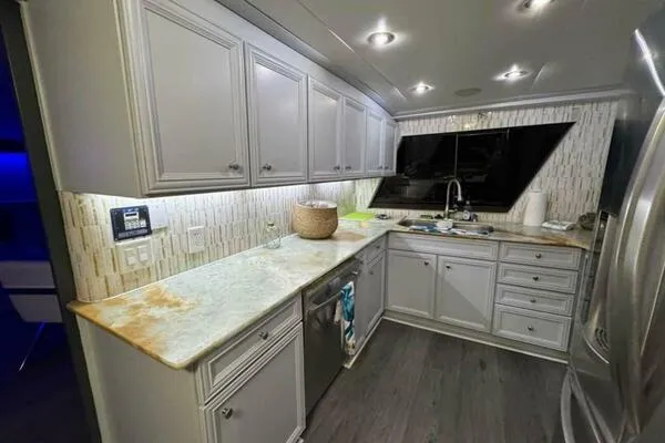 Still Pure Joy Yacht Photos Pics Modern kitchen interior on a 1987 Hatteras 63 yacht with sleek cabinetry and countertops.