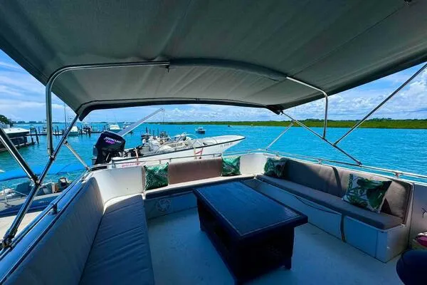 Still Pure Joy Yacht Photos Pics 1987 Hatteras 63 yacht with shaded seating area overlooking serene blue waters.