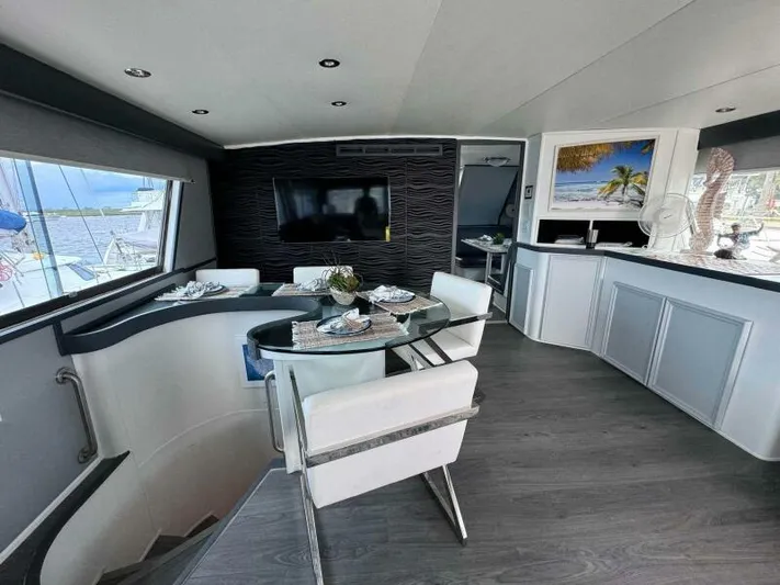 Still Pure Joy Yacht Photos Pics Luxurious interior of a 1987 Hatteras 63 yacht with modern dining area and scenic views.