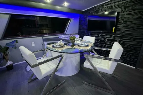 Still Pure Joy Yacht Photos Pics Luxurious dining area on a 1987 Hatteras 63 yacht with modern decor and ambient lighting.
