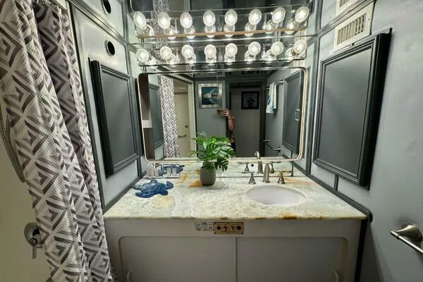 Still Pure Joy Yacht Photos Pics Luxurious bathroom in a 1987 Hatteras 63 yacht with elegant lighting and modern fixtures.