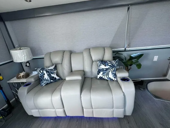 Still Pure Joy Yacht Photos Pics Luxurious gray recliner sofa with tropical pillows in a 1987 Hatteras 63 yacht interior.