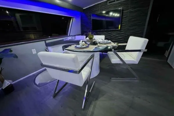 Still Pure Joy Yacht Photos Pics Luxurious dining area inside a 1987 Hatteras 63 yacht with modern decor.