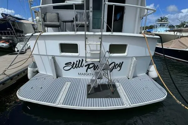 Still Pure Joy Yacht Photos Pics 1987 Hatteras 63 yacht docked, rear view with "Still Pure Joy" text.