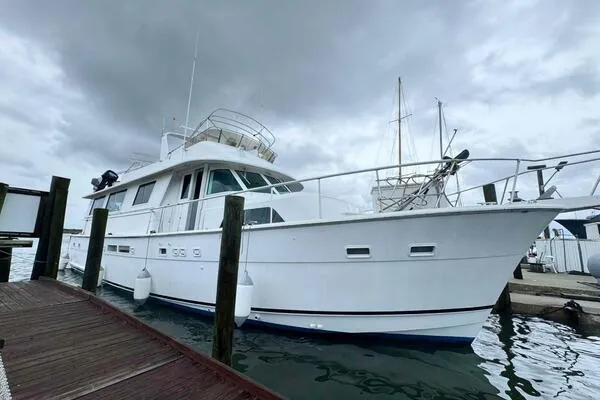 Still Pure Joy Yacht Photos Pics 1987 Hatteras 63 yacht docked under cloudy skies.
