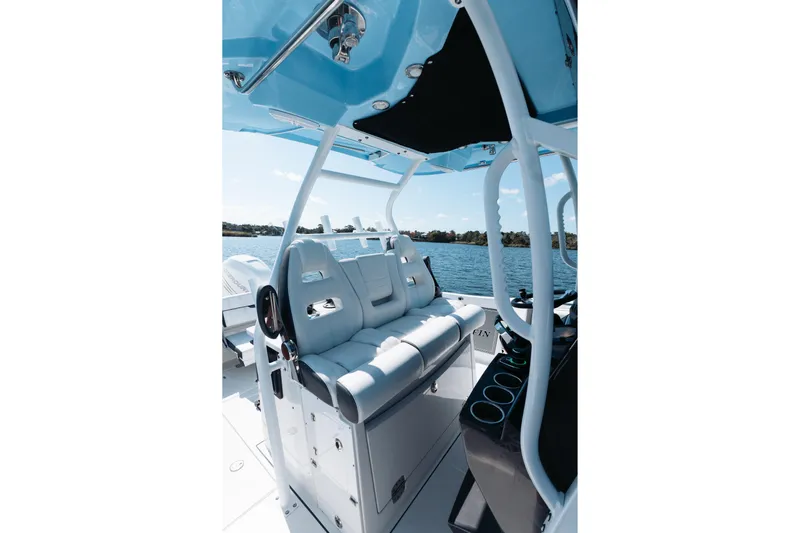 Lickety-split Yacht Photos Pics 2021 Blackfin 332 CC boat interior with white seating and blue canopy on water.