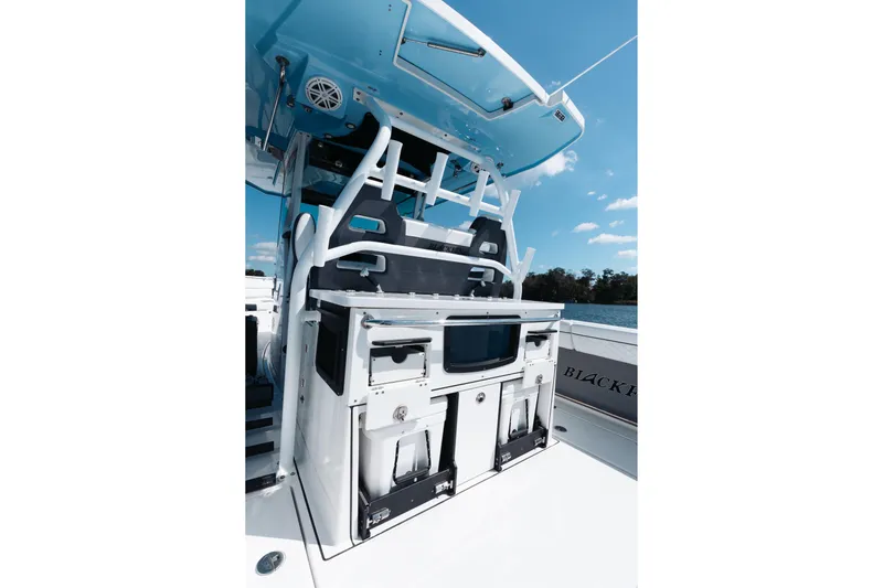 Lickety-split Yacht Photos Pics 2021 Blackfin 332 CC boat interior with storage and seating, under a clear blue sky.