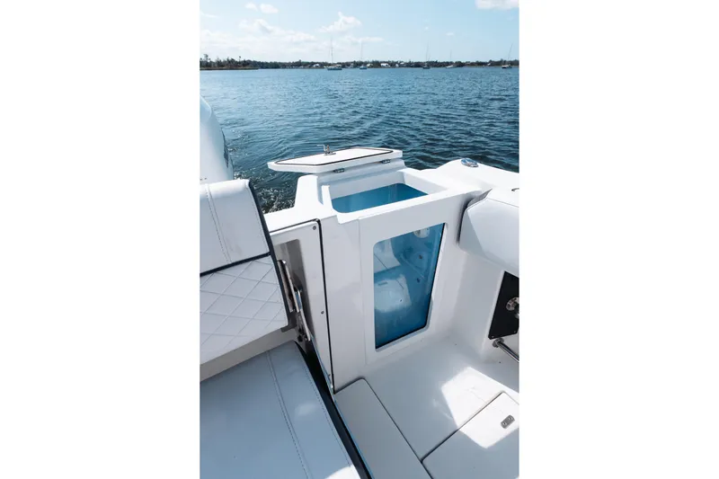 Lickety-split Yacht Photos Pics 2021 Blackfin 332 CC boat interior with seating and storage, overlooking calm waters.