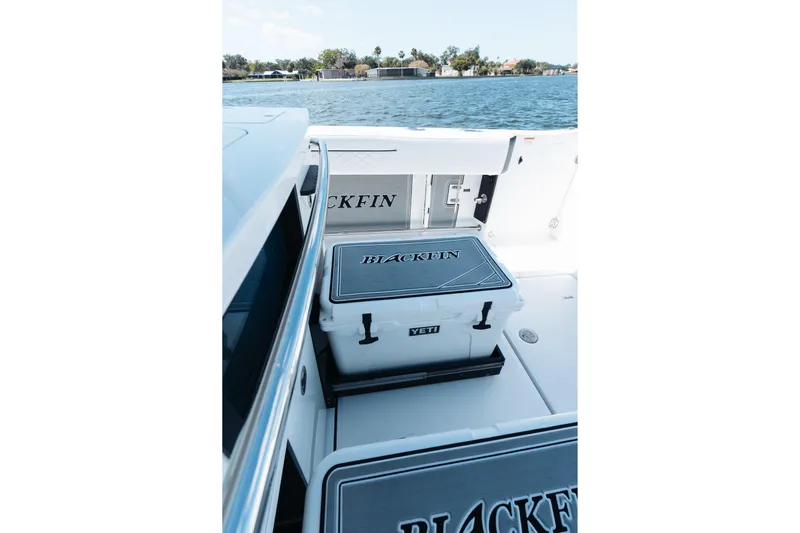 Lickety-split Yacht Photos Pics 2021 Blackfin 332 CC boat with Yeti cooler on deck, overlooking serene water.
