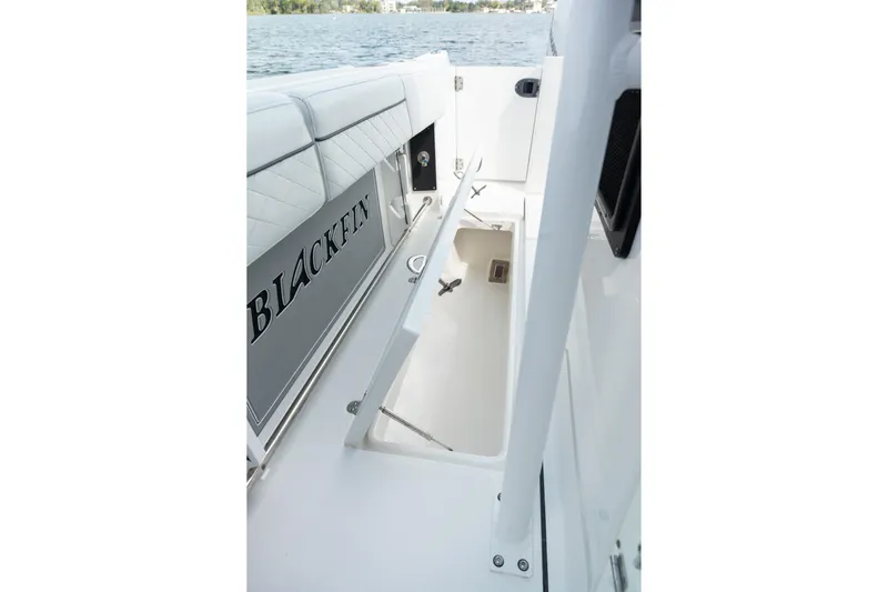 Lickety-split Yacht Photos Pics 2021 Blackfin 332 CC boat interior with open storage compartment, near water.