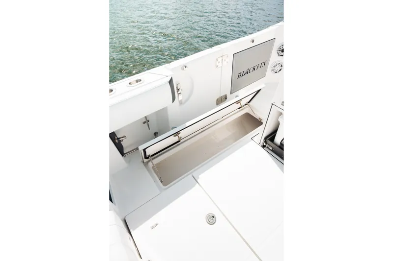 Lickety-split Yacht Photos Pics 2021 Blackfin 332 CC boat interior with open storage compartment by the water.