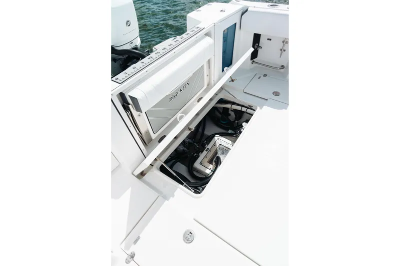 Lickety-split Yacht Photos Pics 2021 Blackfin 332 CC boat with open storage compartment and visible engine components.