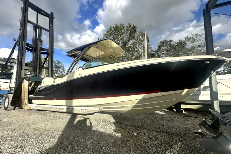  Yacht Photos Pics 2026 Chris-Craft Calypso 28 boat on a lift under a cloudy sky.