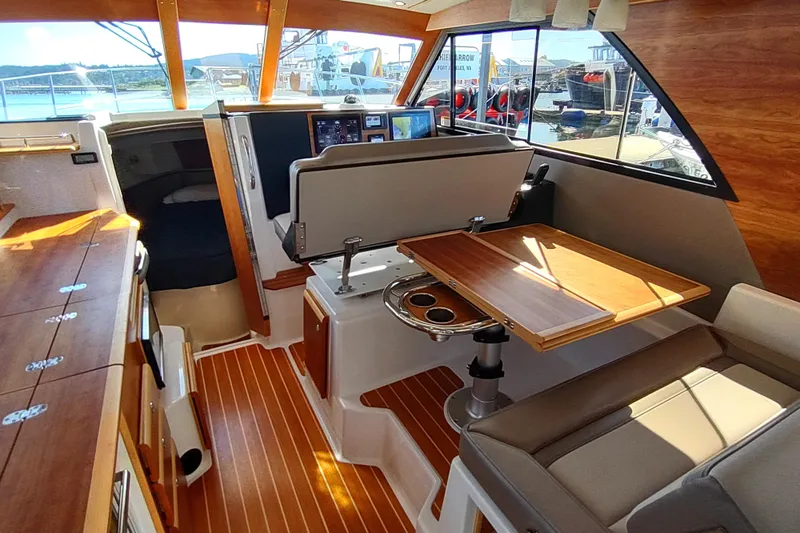 Wyvern Yacht Photos Pics Interior of 2020 Cutwater C-32 Coupe boat with wood accents and seating area.