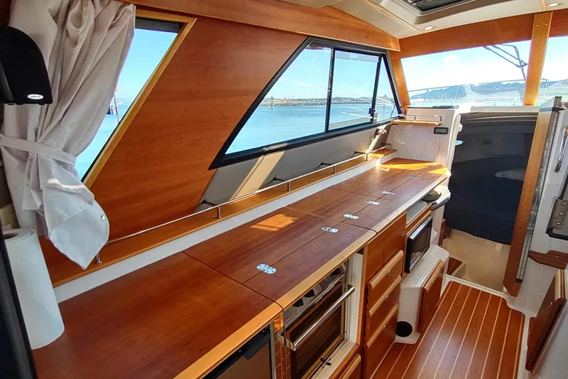Wyvern Yacht Photos Pics Interior of 2020 Cutwater C-32 Coupe with wooden cabinetry and large windows.
