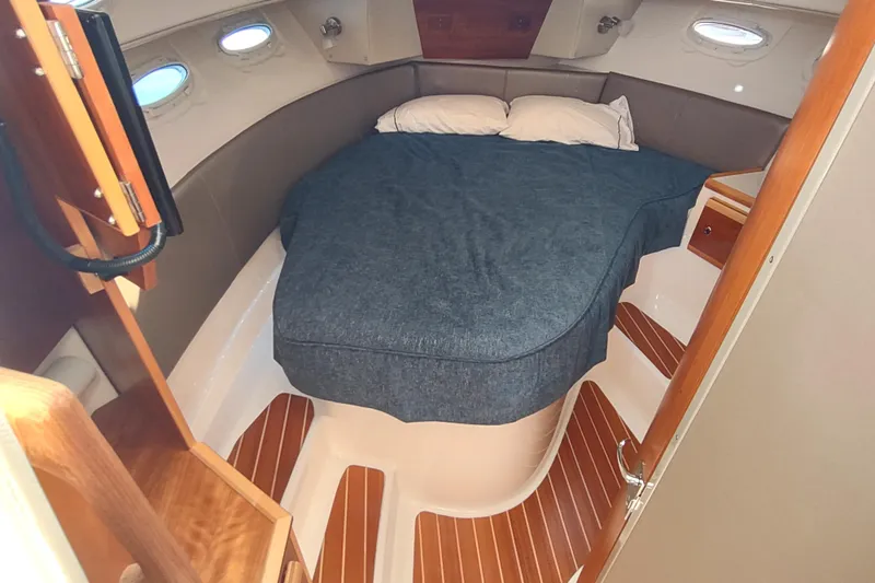 Wyvern Yacht Photos Pics 2020 Cutwater C-32 Coupe cabin interior with cozy bed and wooden accents.
