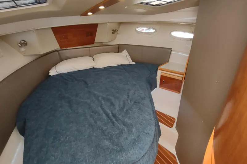 Wyvern Yacht Photos Pics 2020 Cutwater C-32 Coupe cabin interior with cozy bed and wooden accents.
