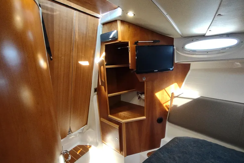 Wyvern Yacht Photos Pics 2020 Cutwater C-32 Coupe interior with wood finish, shelves, and a mounted TV.