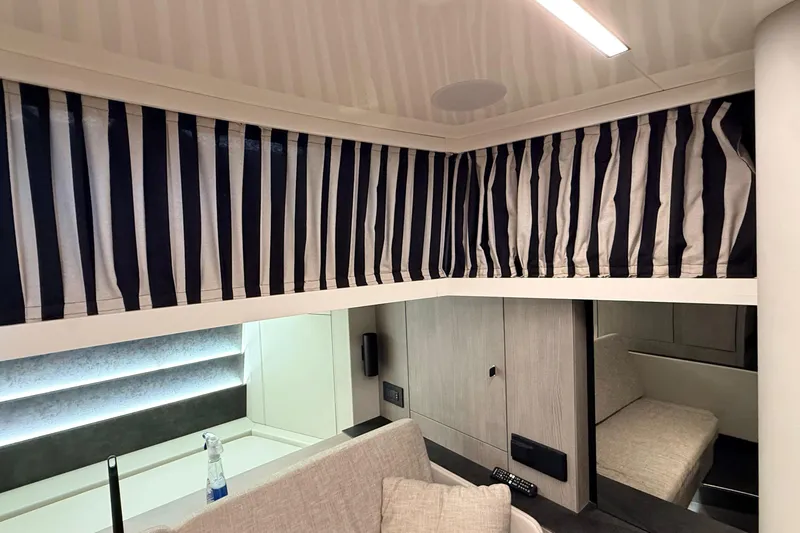  Yacht Photos Pics Interior of 2022 Cranchi A46 Luxury Tender with striped curtains and modern furnishings.