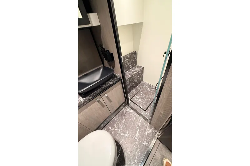  Yacht Photos Pics Luxurious bathroom interior of 2022 Cranchi A46 Luxury Tender with marble flooring.