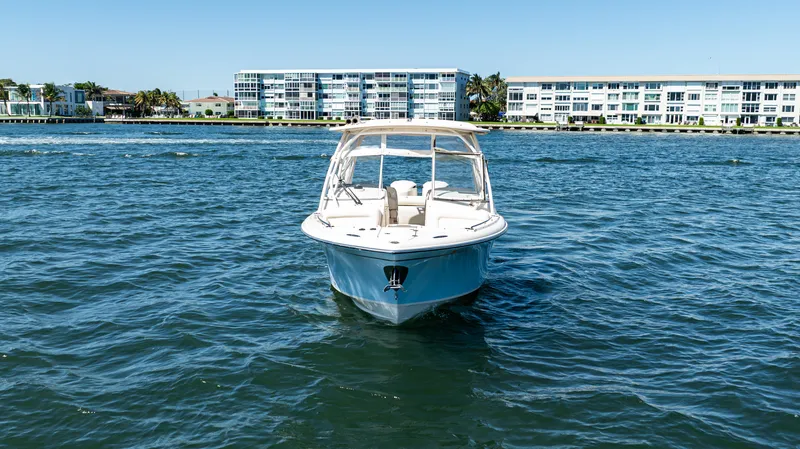  Yacht Photos Pics 2020 Grady-White Freedom 285 boat on water with coastal buildings in background.