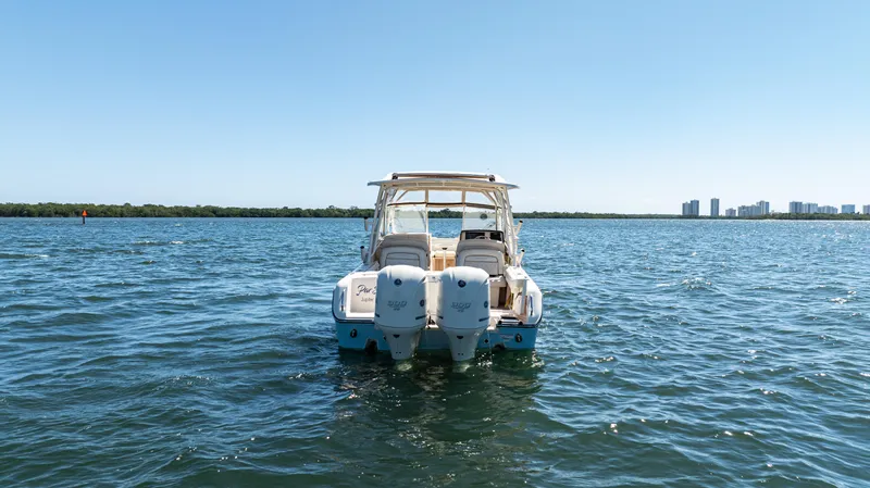  Yacht Photos Pics 2020 Grady-White Freedom 285 boat on open water with city skyline in background.