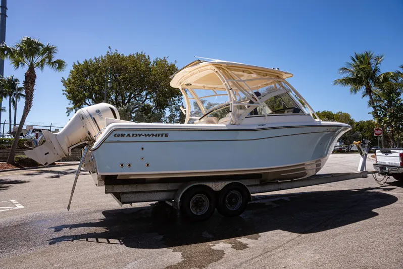  Yacht Photos Pics 2020 Grady-White Freedom 285 boat on trailer, parked under clear blue sky.