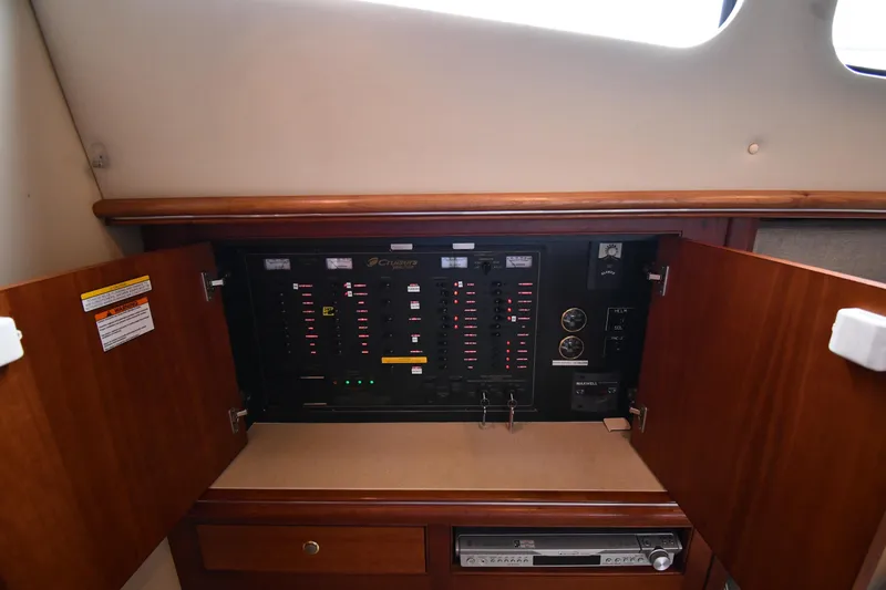 Core Values Yacht Photos Pics 2007 Cruisers Yachts 455 Express Motoryacht electrical panel with open wooden cabinet doors.