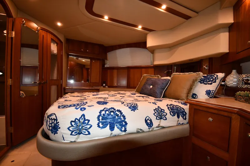 Core Values Yacht Photos Pics Luxurious bedroom interior of 2007 Cruisers Yachts 455 Express Motoryacht with elegant wood finishes.