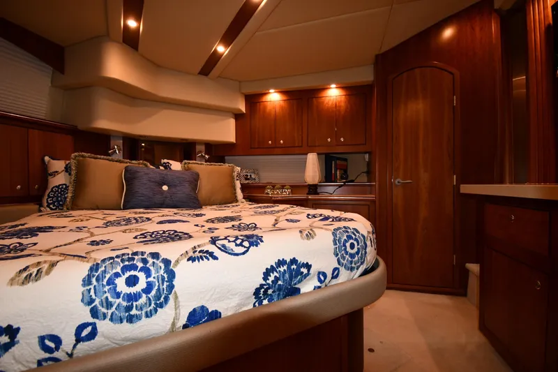 Core Values Yacht Photos Pics Luxurious bedroom interior of 2007 Cruisers Yachts 455 Express Motoryacht with elegant wood finishes.