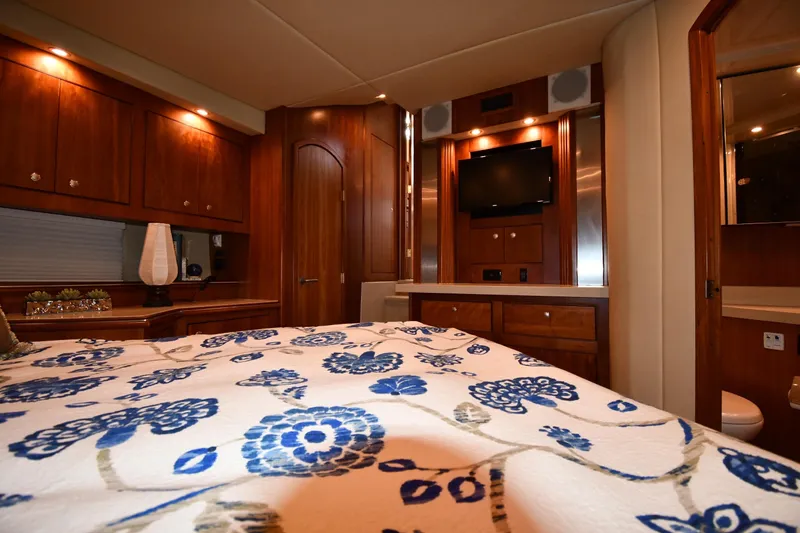 Core Values Yacht Photos Pics Luxurious 2007 Cruisers Yachts 455 Express Motoryacht bedroom with elegant wood cabinetry.