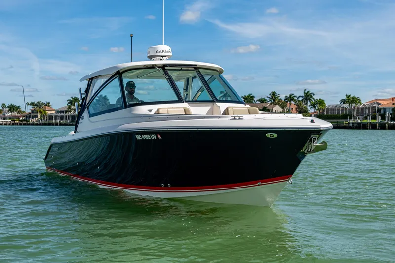  Yacht Photos Pics 2017 Pursuit DC 295 Dual Console boat cruising on clear waters under a blue sky.