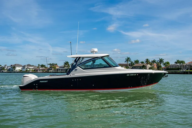  Yacht Photos Pics 2017 Pursuit DC 295 Dual Console boat cruising on calm waters under a clear blue sky.