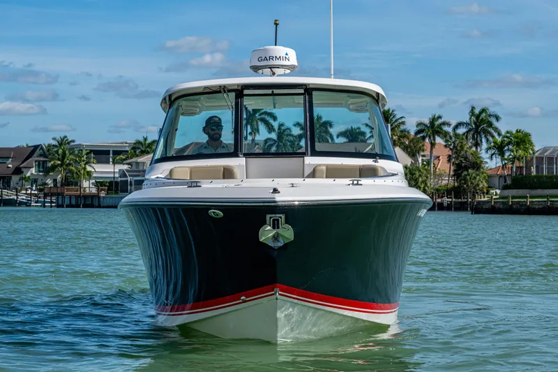  Yacht Photos Pics 2017 Pursuit DC 295 Dual Console boat on water, with palm trees in the background.