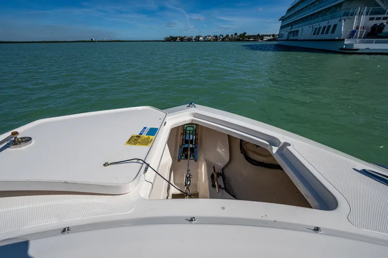  Yacht Photos Pics 2017 Pursuit DC 295 Dual Console boat on calm water, open storage compartment visible.