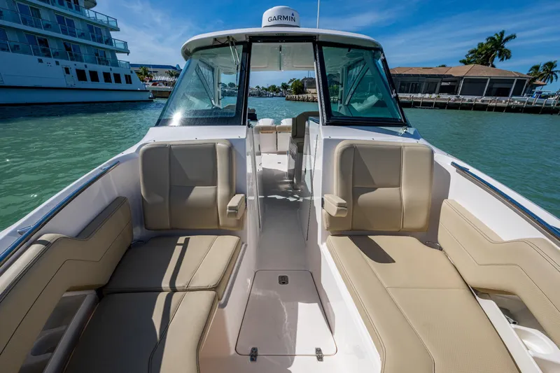  Yacht Photos Pics 2017 Pursuit DC 295 Dual Console boat interior with beige seating, docked in sunny marina.