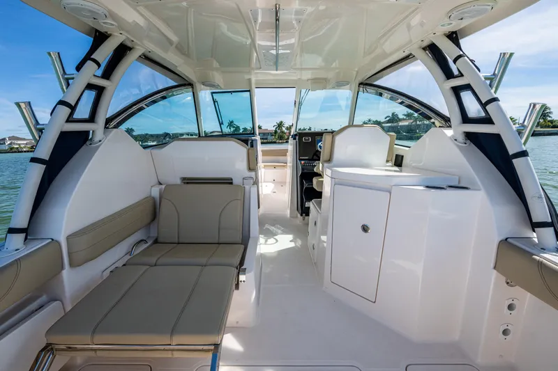  Yacht Photos Pics 2017 Pursuit DC 295 Dual Console boat interior with seating and helm, on a sunny day.