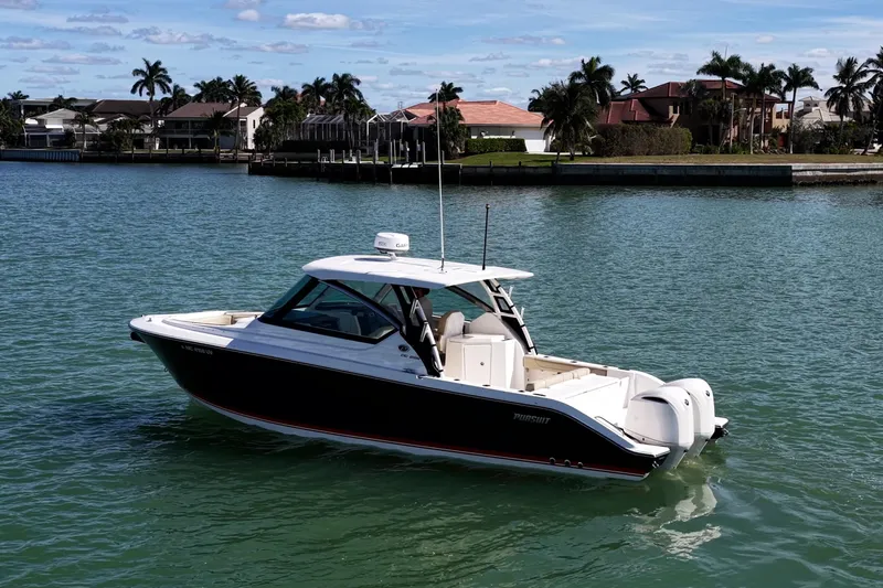  Yacht Photos Pics 2017 Pursuit DC 295 Dual Console boat on calm water near waterfront homes.