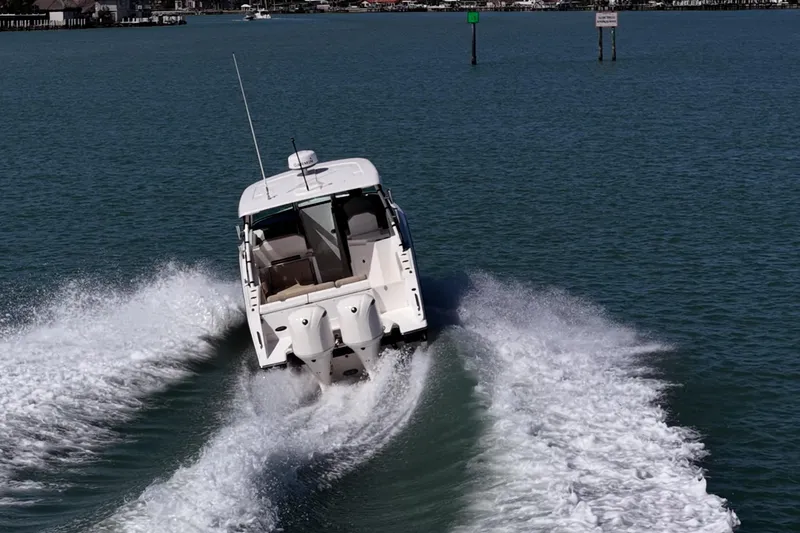  Yacht Photos Pics 2017 Pursuit DC 295 Dual Console boat cruising on open water, creating a dynamic wake.