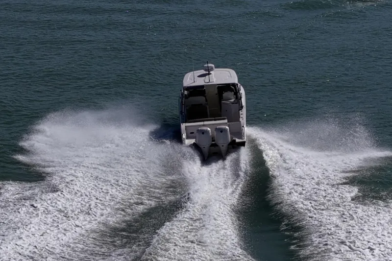  Yacht Photos Pics 2017 Pursuit DC 295 Dual Console boat cruising on open water, leaving a wake.