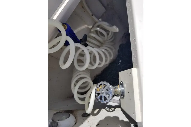 Ships N Giggles Yacht Photos Pics Coiled hose and valve in 2018 Regal 35 Sport Coupe boat compartment.