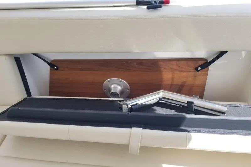 Ships N Giggles Yacht Photos Pics 2018 Regal 35 Sport Coupe interior storage compartment with metal fittings and wooden panel.